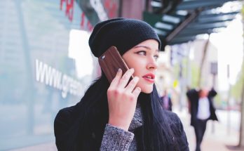 Frau mit Handyhülle in Holzoptik